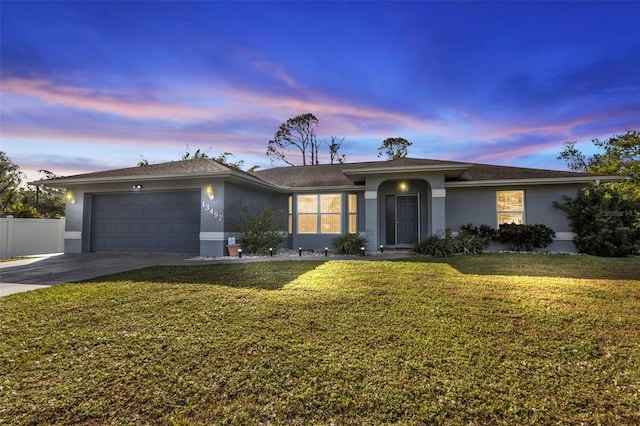 ranch-style home featuring a yard and a garage