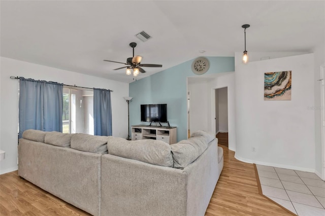 living room with ceiling fan, lofted ceiling, and light hardwood / wood-style flooring