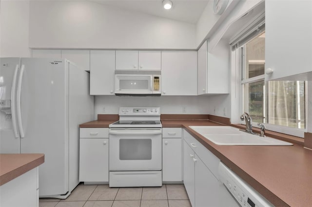 kitchen featuring sink, light tile patterned floors, lofted ceiling, white appliances, and white cabinets