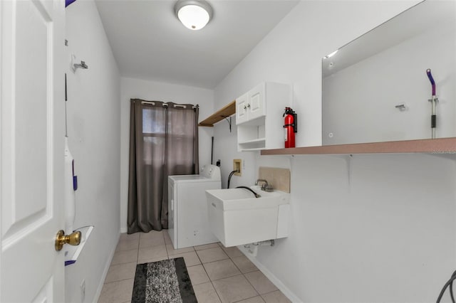 laundry room with light tile patterned flooring, washer and clothes dryer, and sink