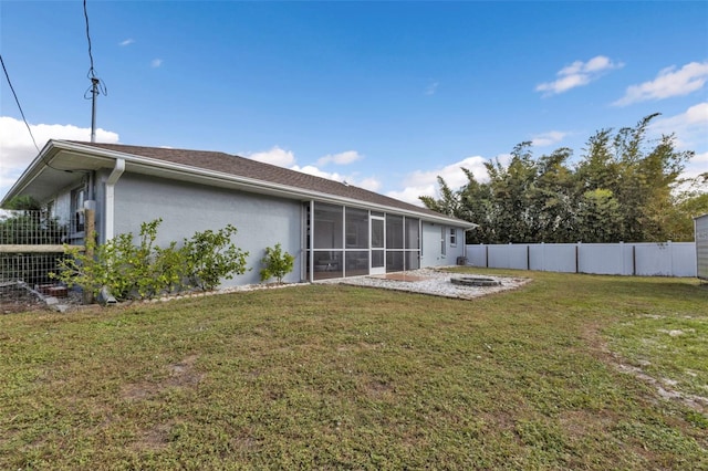 rear view of property with a sunroom and a lawn