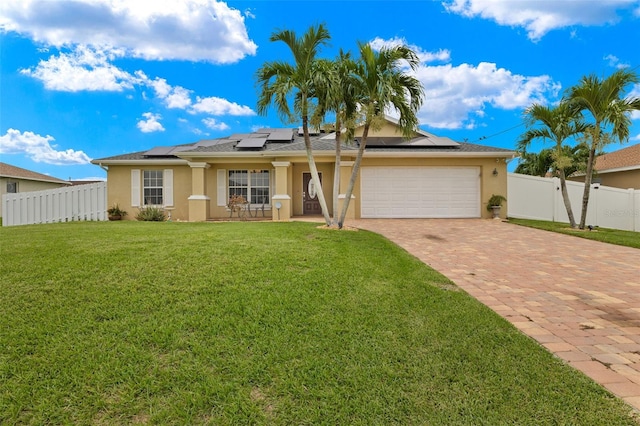 single story home with solar panels, a front yard, and a garage