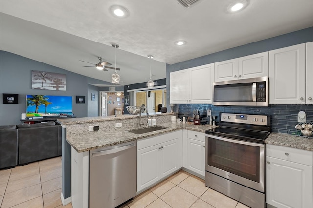 kitchen featuring light tile patterned flooring, white cabinetry, appliances with stainless steel finishes, kitchen peninsula, and lofted ceiling