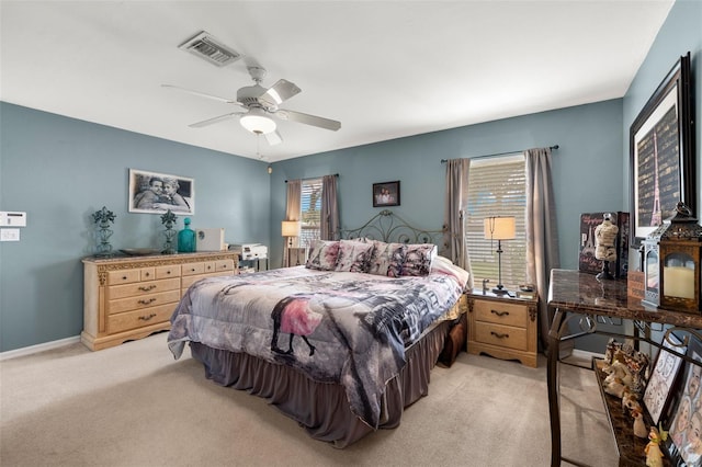 bedroom with light colored carpet, multiple windows, and ceiling fan