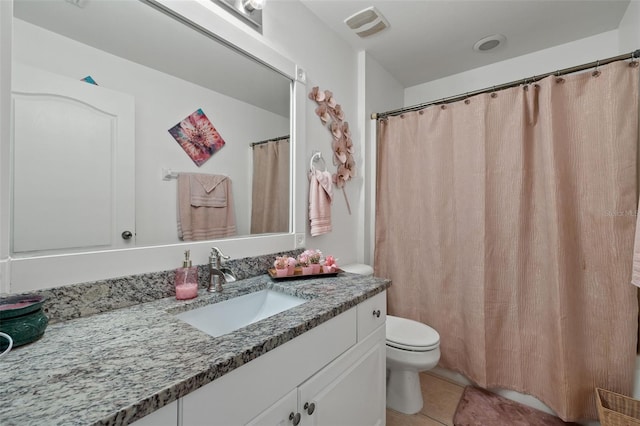 bathroom with tile patterned flooring, vanity, and toilet