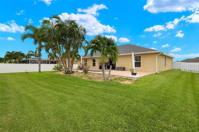 rear view of property featuring a patio and a yard