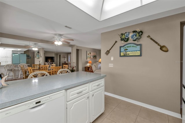 kitchen with white dishwasher, light tile patterned flooring, and white cabinets