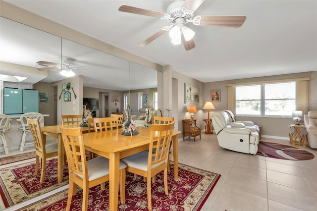 dining area with ceiling fan, light tile patterned flooring, and a skylight