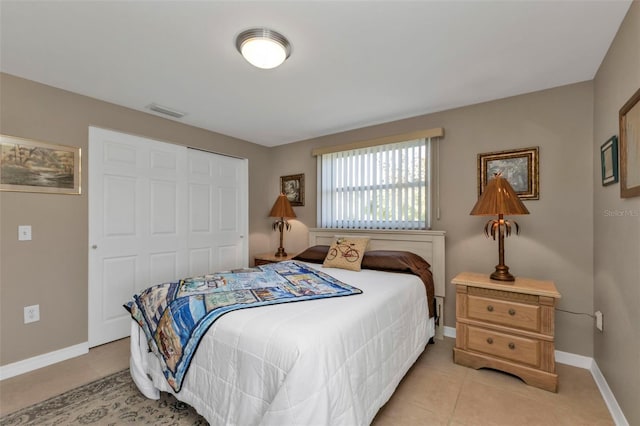 bedroom with light tile patterned floors and a closet