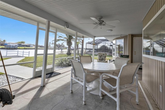 sunroom with plenty of natural light, ceiling fan, and a water view