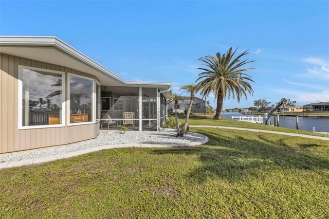 view of yard featuring a water view and a sunroom