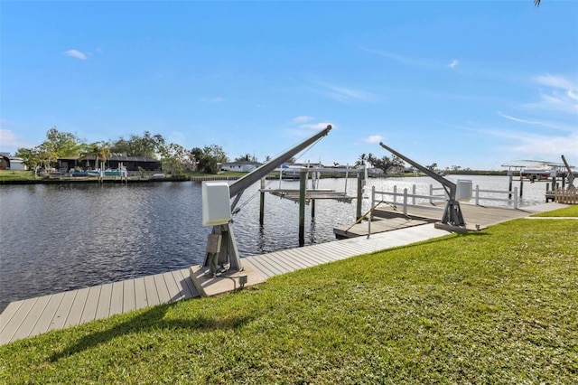 view of dock with a yard and a water view