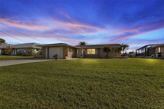 ranch-style home featuring a lawn and a garage