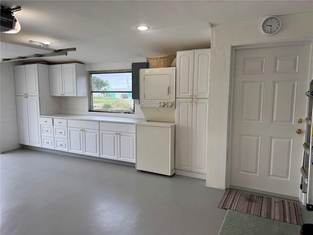 interior space with stacked washing maching and dryer and a garage door opener