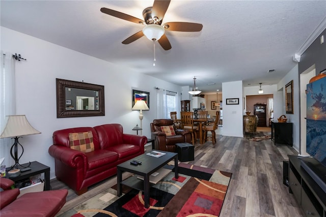 living room with a textured ceiling, dark hardwood / wood-style flooring, and ceiling fan