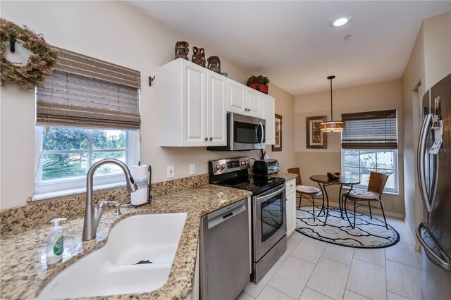 kitchen featuring white cabinets, a wealth of natural light, stainless steel appliances, and sink