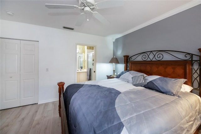 bedroom with ensuite bath, ornamental molding, ceiling fan, light hardwood / wood-style flooring, and a closet