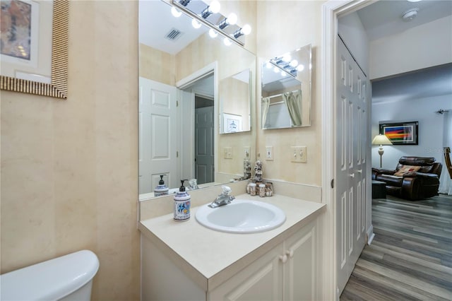 bathroom featuring toilet, vanity, and hardwood / wood-style floors