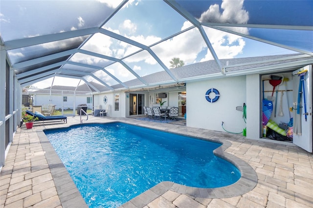 view of swimming pool featuring glass enclosure and a patio area