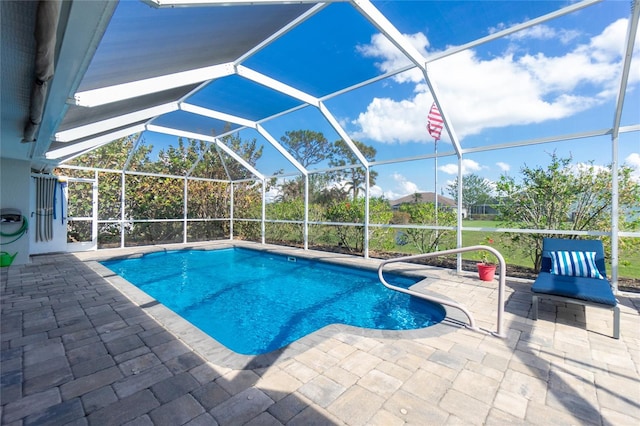 view of pool with glass enclosure and a patio area