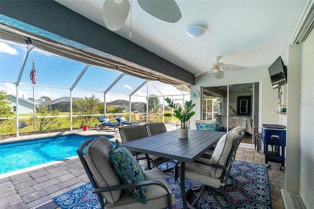 view of pool with a patio, ceiling fan, and glass enclosure