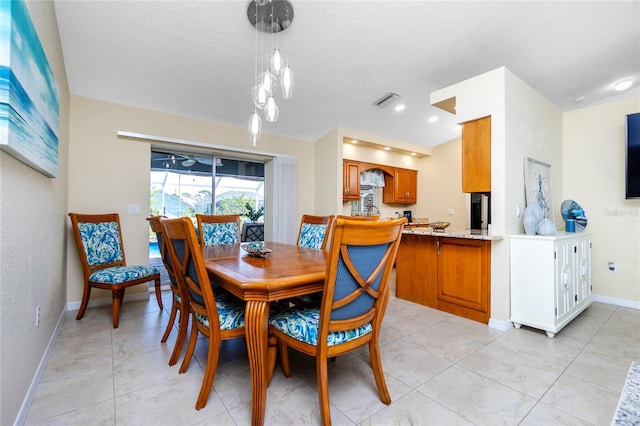 tiled dining room featuring a textured ceiling