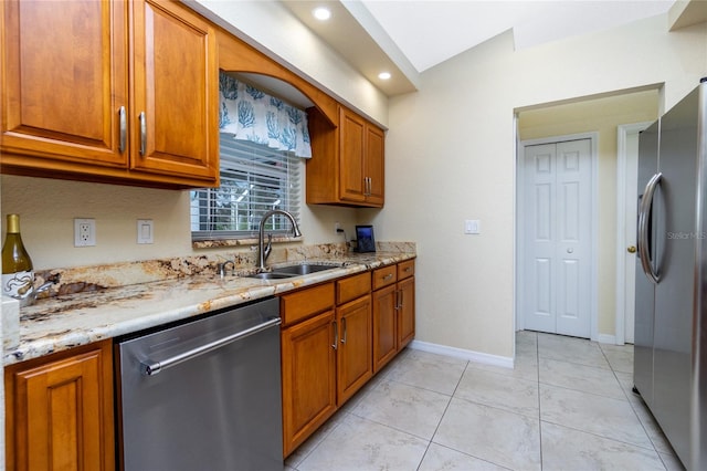 kitchen featuring light stone countertops, appliances with stainless steel finishes, sink, and light tile patterned floors