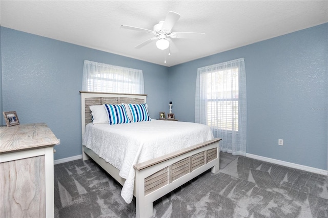 bedroom with ceiling fan and dark carpet