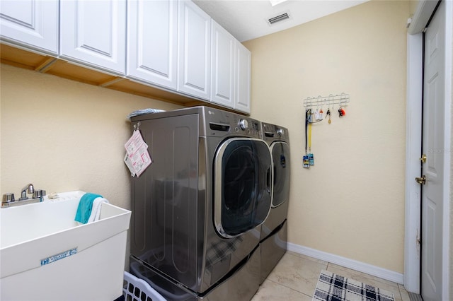 laundry room with cabinets, separate washer and dryer, light tile patterned floors, and sink