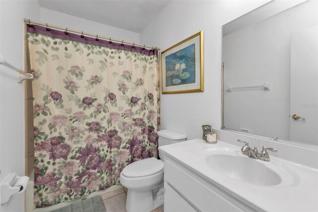 bathroom featuring tile patterned flooring, curtained shower, vanity, and toilet