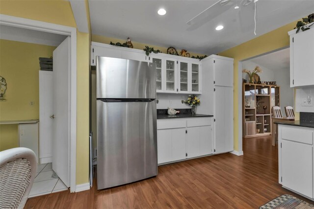 kitchen with ceiling fan, light hardwood / wood-style floors, stainless steel fridge, and white cabinets