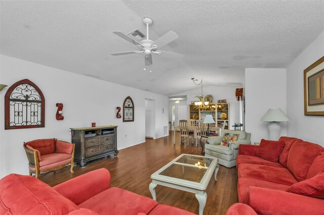 living room with dark hardwood / wood-style flooring, ceiling fan with notable chandelier, a textured ceiling, and lofted ceiling