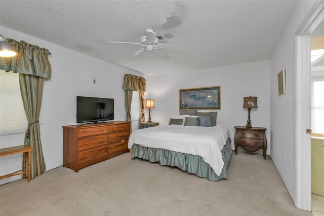 bedroom with a textured ceiling, light carpet, and ceiling fan