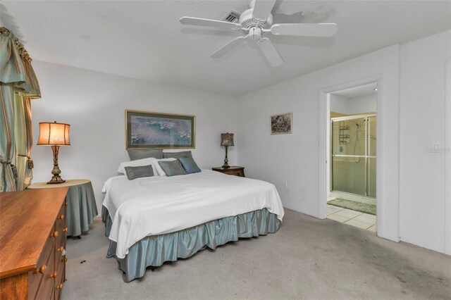 bedroom featuring light carpet, ceiling fan, and connected bathroom