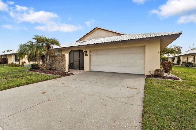 single story home featuring a garage and a front lawn