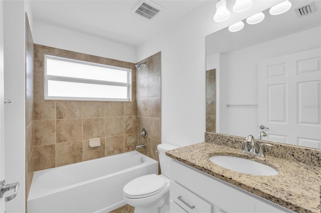 full bathroom featuring tiled shower / bath combo, toilet, and vanity