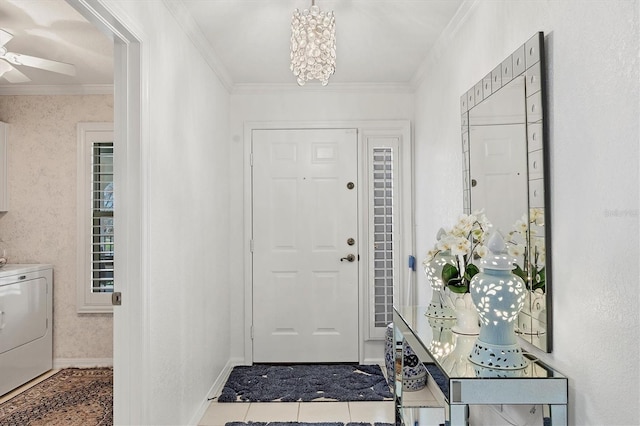 tiled foyer with washer / dryer, ornamental molding, and a chandelier