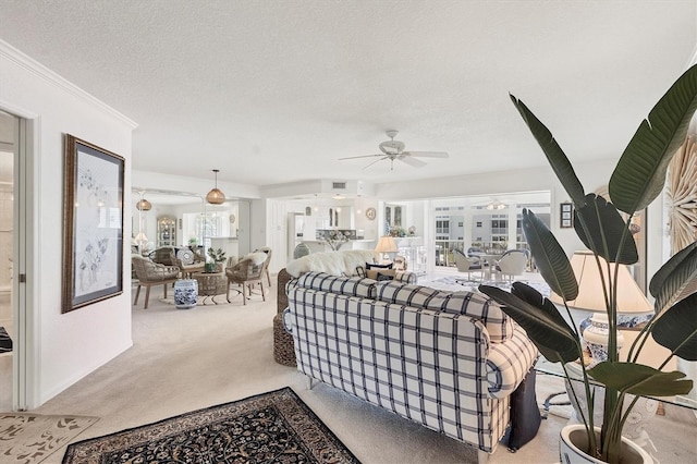 living room with ceiling fan, ornamental molding, a textured ceiling, and light carpet