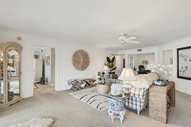 carpeted living room with ceiling fan and crown molding