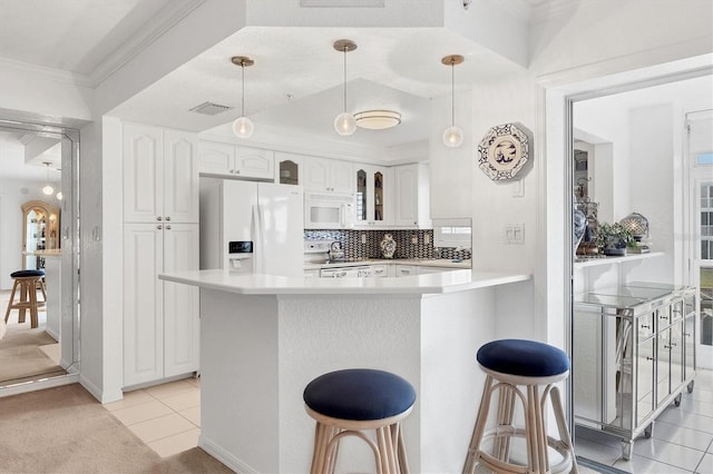 kitchen featuring a breakfast bar, white appliances, light colored carpet, crown molding, and white cabinets