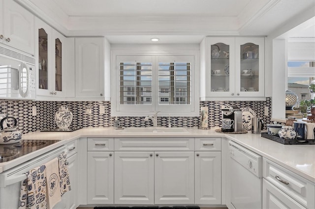 kitchen featuring decorative backsplash, sink, white cabinets, and white appliances