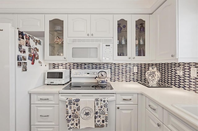 kitchen featuring white cabinets, decorative backsplash, and white appliances