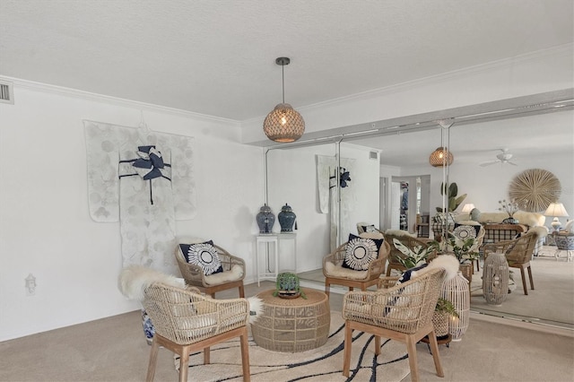 sitting room with light colored carpet, ornamental molding, and a textured ceiling