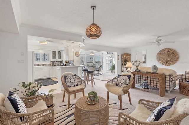 living room featuring ceiling fan and a textured ceiling