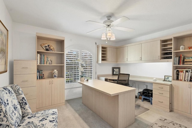 carpeted home office featuring ceiling fan