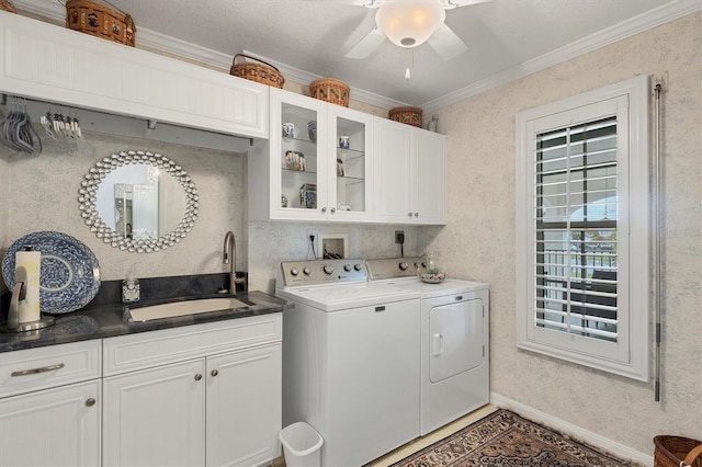 laundry area featuring crown molding, cabinets, sink, and washing machine and dryer