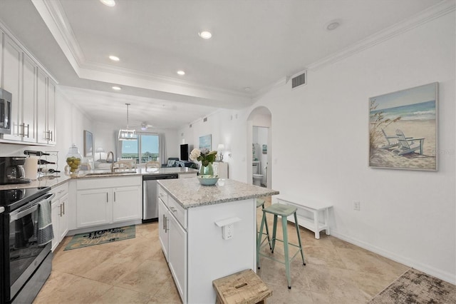 kitchen with a center island, sink, crown molding, white cabinetry, and appliances with stainless steel finishes