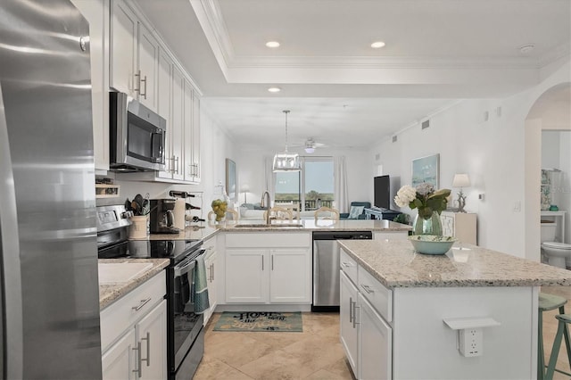 kitchen with kitchen peninsula, hanging light fixtures, sink, white cabinetry, and appliances with stainless steel finishes