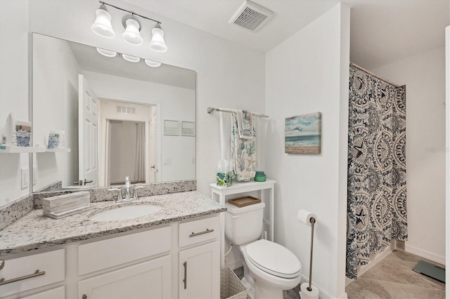 bathroom featuring tile patterned flooring, vanity, and toilet