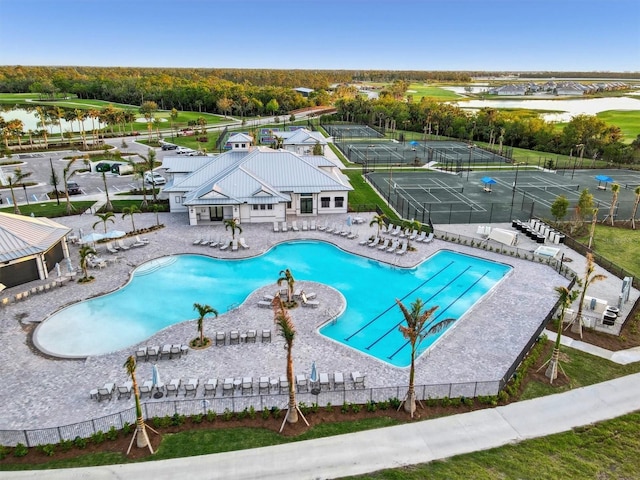 view of pool featuring a lanai, a water view, and a patio area